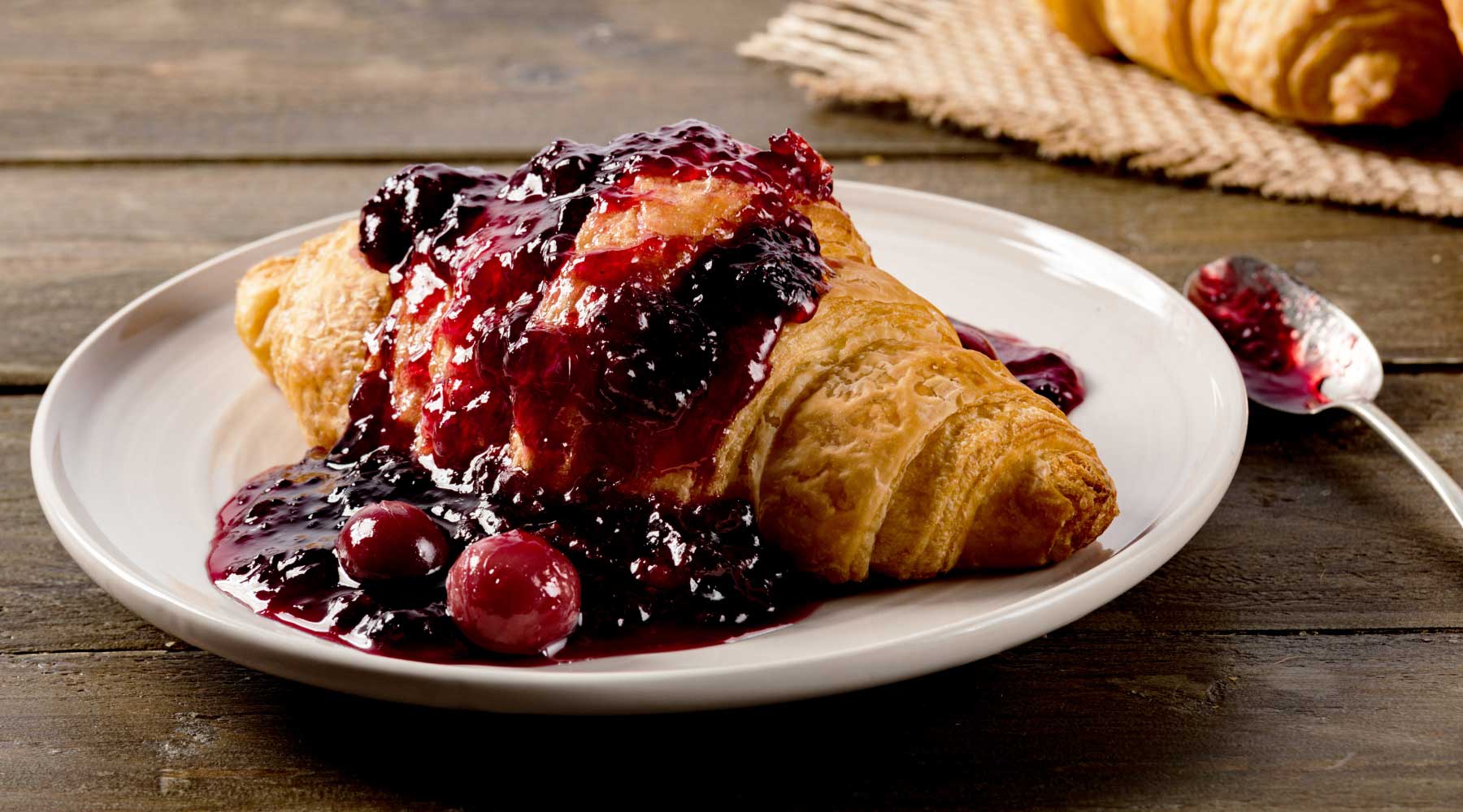 Croissant covered with berry fruit jam